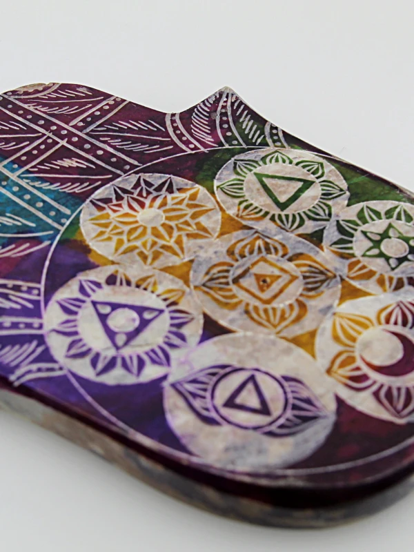 O porta-incenso em pedra de sabão com mão e chakras é uma peça funcional e resistente