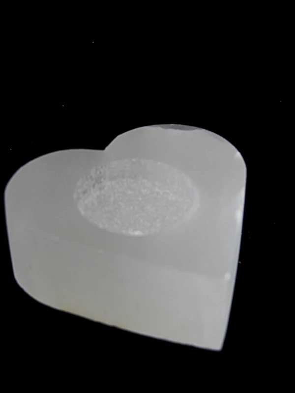 O castiçal de selenita em forma de coração é uma peça delicada